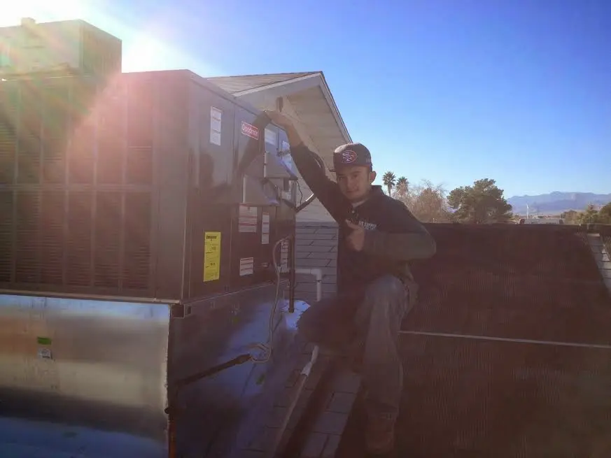 HVAC technician performing AC Tune-Up on a rooftop unit in Wilmette